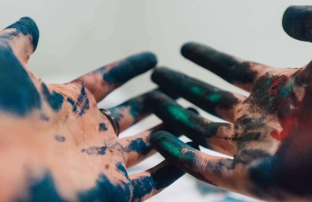 Azure, or blue-green paint on hands