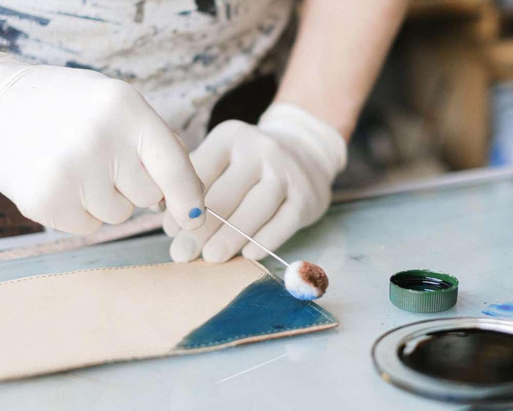 Applying paint on a piece of leather