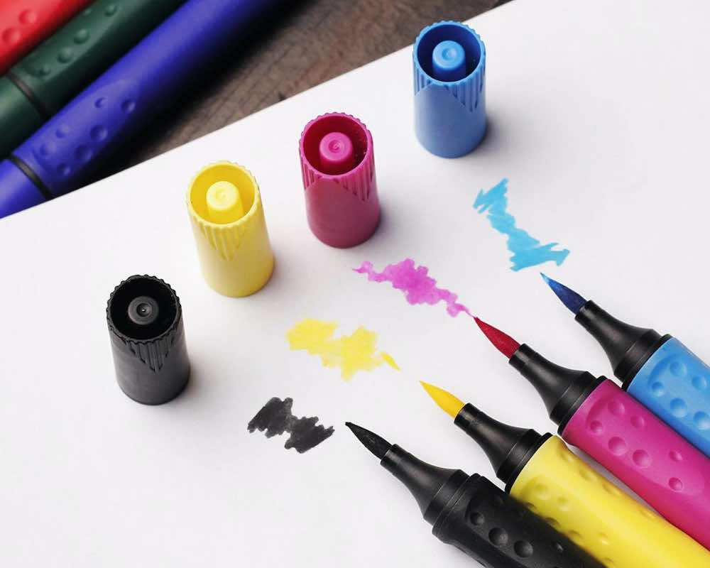 Brush pens in black, yellow, pink and blue