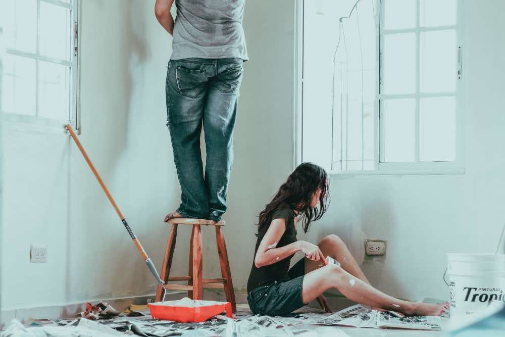 A couple painting the walls at home
