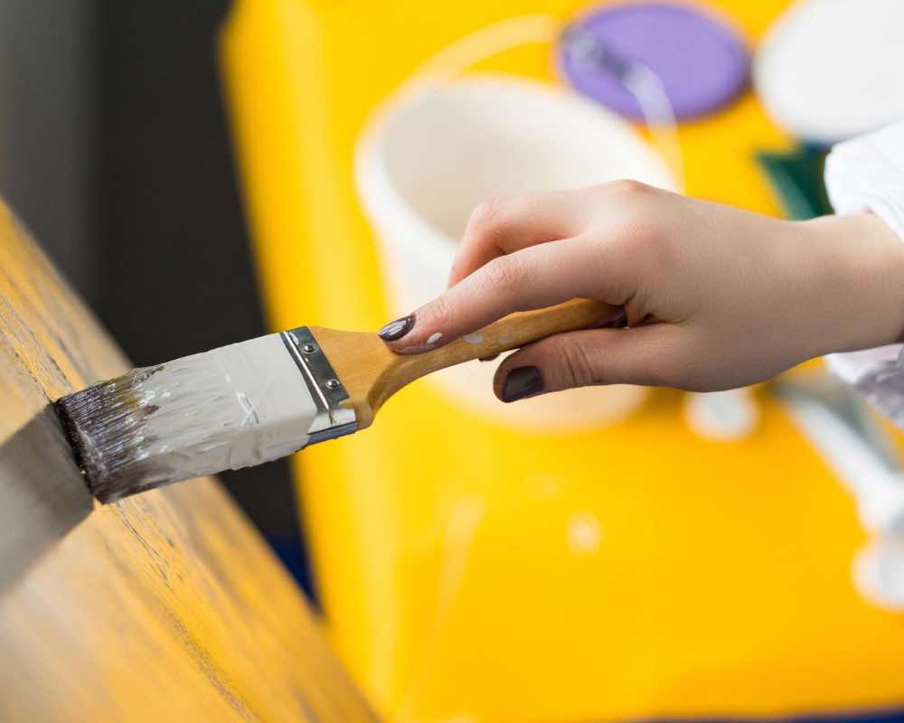 A brush in hand, painting yellow