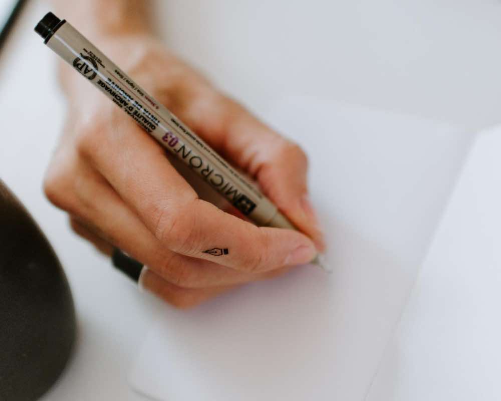 A person holding a micron pen
