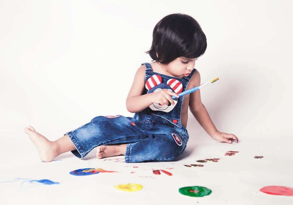 A child surrounded by paint