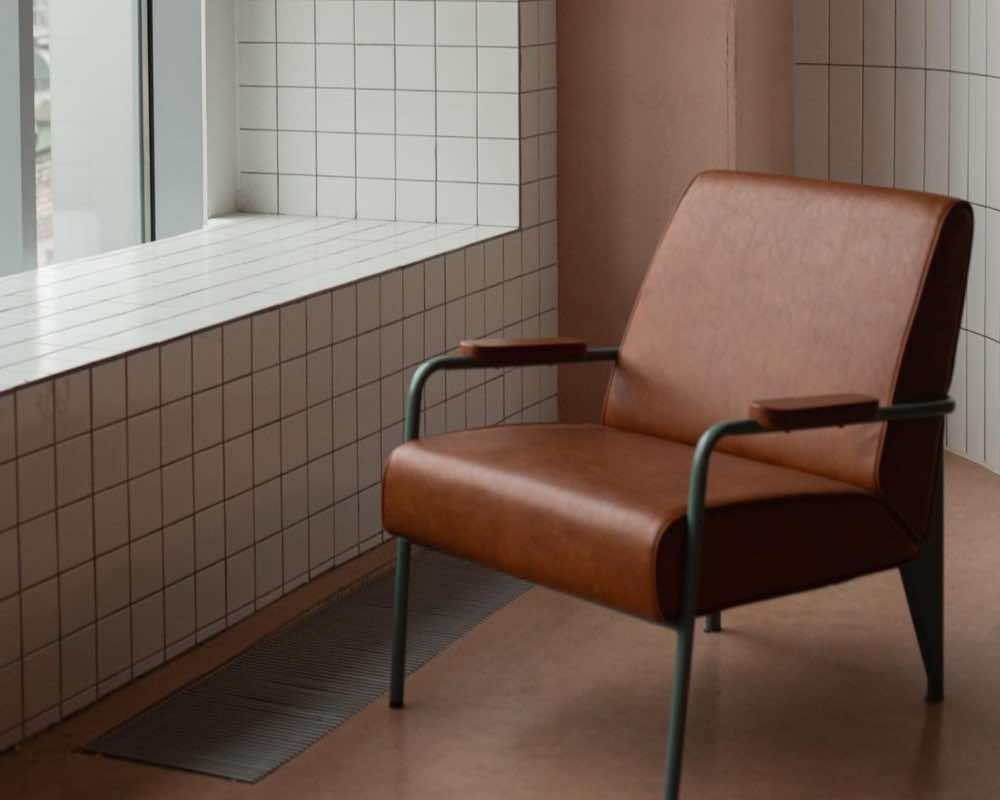 A brown chair in a room with brown and white interior