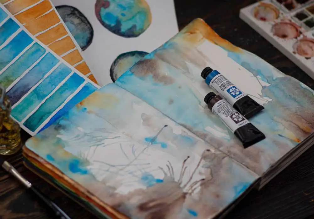 An art journal having corners decorated with watercolor